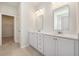 Bright bathroom with double sink vanity with quartz countertops, white cabinets, and tiled floors at 1251 Wading Point Blvd, Huger, SC 29450