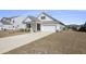 Inviting single-story home showcasing a clean facade, attached garage, and freshly planted greenery at 1251 Wading Point Blvd, Huger, SC 29450