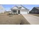 Single-story home featuring a manicured lawn, two-car garage, and covered porch with classic design at 1251 Wading Point Blvd, Huger, SC 29450