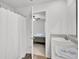 Bathroom with a white shower curtain partially open to view a neutral bedroom with carpet at 127 Rosefield Ct, Summerville, SC 29485