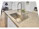 Close-up of the kitchen island featuring a stainless steel sink, faucet, and neutral countertop at 127 Rosefield Ct, Summerville, SC 29485