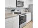 Kitchen boasts stainless steel appliances, sleek countertops, white cabinets, and modern backsplash at 127 Rosefield Ct, Summerville, SC 29485