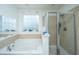 Bright bathroom featuring a soaking tub, separate shower, and a frosted window for natural light at 1273 Discovery Dr, Ladson, SC 29456
