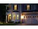 Charming two-story home with well-lit landscaping, a two-car garage, and inviting front porch at twilight at 1273 Discovery Dr, Ladson, SC 29456