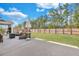 Expansive backyard with lush green grass, mature trees, and a concrete patio with patio furniture at 130 Wappoo Trace Ln, Summerville, SC 29486