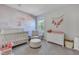 Light-filled Bedroom with whimsical wallpaper, crib, and cozy chair at 130 Wappoo Trace Ln, Summerville, SC 29486