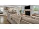 Open-concept living room boasts a fireplace, flat screen tv, and seamless flow to kitchen at 130 Wappoo Trace Ln, Summerville, SC 29486