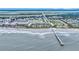 Expansive aerial view of oceanfront condos near a fishing pier, blending coastal charm and modern convenience at 1300 Ocean Blvd # 114 A, Isle of Palms, SC 29451