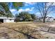 Large backyard with a grassy area, mature trees, and a storage shed at 1409 Main St, Bonneau, SC 29431