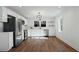 Bright kitchen showcasing stainless steel appliances, white cabinets, a stylish light fixture, and wood floors at 1409 Main St, Bonneau, SC 29431