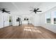 Sun-filled living area with a partial view of the kitchen, wood floors, and modern lighting fixtures at 1409 Main St, Bonneau, SC 29431