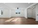 Open living room featuring wood floors, a ceiling fan, and natural light from the windows overlooking the yard at 1409 Main St, Bonneau, SC 29431