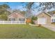 Charming single-story home features a manicured lawn, white picket fence and attached garage at 143 Moon Dance Ln, Summerville, SC 29483