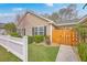 Exterior view of charming single story home with an orange gate and white picket fence at 143 Moon Dance Ln, Summerville, SC 29483