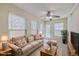 Stylish living room with neutral carpet, ceiling fan, and lots of windows, creating a versatile and inviting gathering area at 143 Moon Dance Ln, Summerville, SC 29483