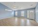 Bright living room with a ceiling fan, light wood floors, and several windows at 143 Moon Dance Ln, Summerville, SC 29483