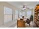 Comfortable office with neutral carpet, ceiling fan, lots of windows, and a built-in bookcase for organization and relaxation at 143 Moon Dance Ln, Summerville, SC 29483
