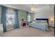Main bedroom features an electric fireplace, large windows, and a plush bed with blue accents at 162 Cherry Grv Dr, Summerville, SC 29483