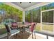 Screened porch with seating area, table, and views of the yard at 162 Cherry Grv Dr, Summerville, SC 29483