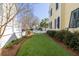 Lush backyard featuring a well-manicured lawn with flowerbeds, complemented by a classic yellow home exterior at 1676 Paradise Lake Dr, Mount Pleasant, SC 29464
