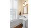 Traditional bathroom features a pedestal sink, shuttered windows, and wood floors at 1676 Paradise Lake Dr, Mount Pleasant, SC 29464