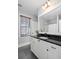 Bright bathroom showcasing a vanity with black countertops, large mirror, and neutral paint at 1676 Paradise Lake Dr, Mount Pleasant, SC 29464