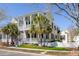 Charming two-story yellow home with white porch railings and palm trees lining the front at 1676 Paradise Lake Dr, Mount Pleasant, SC 29464
