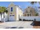 Detached two-car garage with a white door and a charming yellow exterior matching the house at 1676 Paradise Lake Dr, Mount Pleasant, SC 29464