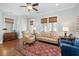 A living room with hardwood floors, multiple windows, and a ceiling fan at 1676 Paradise Lake Dr, Mount Pleasant, SC 29464