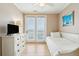 Cozy bedroom featuring a twin bed, dresser, and bright, open balcony access at 1699 E Ashley Ave # B, Folly Beach, SC 29439
