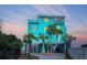 Turquoise beach house with palm trees offers a charming coastal vibe and convenient ground-level parking at 1699 E Ashley Ave # B, Folly Beach, SC 29439