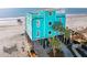 Turquoise beach house featuring balconies, palm trees, and convenient access to the sandy beach at 1699 E Ashley Ave # B, Folly Beach, SC 29439