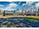 Expansive backyard featuring gravel, green lawn, mature trees, and a screened porch at 1898 Hialeah Ct, Charleston, SC 29414