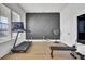 Bright exercise room featuring hardwood floors, a tonal, stationary bike, treadmill and other gym equipment at 201 Symphony Ave, Summerville, SC 29486
