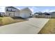 Well-manicured lawn and a spacious driveway lead to the back of the house and the two-car garage at 201 Symphony Ave, Summerville, SC 29486