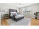 Well-lit bedroom with a tufted headboard bed, hardwood floors, and a ceiling fan at 209 Brailsford Rd, Summerville, SC 29485