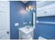 The bathroom features blue walls, a white sink, a mirror, and a light fixture at 211 Trestlewood Dr, Summerville, SC 29486