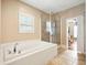 Bathroom featuring a soaking tub, tiled walls, and a glass-enclosed shower, offering a spa-like retreat at 214 Shelby Shea Ln, Moncks Corner, SC 29461