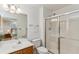 Bright bathroom featuring a glass enclosed shower, wood vanity, and view to the main bedroom at 2634 Lani Ct, Charleston, SC 29414