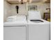 Bright laundry room featuring white washer, dryer, and storage shelves at 2774 Hidden Oak Dr, Seabrook Island, SC 29455