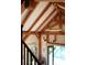 Staircase with exposed beams and chandelier, leading to an open doorway with a view of the pool at 34 Percy St, Charleston, SC 29403