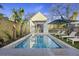 Beautiful backyard pool with palm trees, lounge chairs, and a cozy pool house for relaxation at 34 Percy St, Charleston, SC 29403