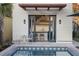 Backyard pool area featuring a pristine pool, outdoor seating, and a pool house with open access to kitchen at 34 Percy St, Charleston, SC 29403