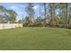 Large backyard showcasing a well-maintained lawn, privacy fence, and mature trees, perfect for outdoor entertaining at 3405 Painswick Rd, Johns Island, SC 29455