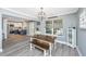 Dining area with an open view to the kitchen, showcasing stylish furniture and natural light through a window at 3405 Painswick Rd, Johns Island, SC 29455