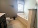 Bright bathroom featuring a soaking tub, tile floors, and a window with blinds at 3614 Haymont Ln, Ladson, SC 29456