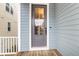 Stylish blue front door with glass inset and sidelight, complemented by a welcoming wooden porch at 3726 Apiary Ln, Johns Island, SC 29455