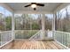 A covered porch with wood floors offers a tranquil outdoor living space surrounded by nature at 3726 Apiary Ln, Johns Island, SC 29455