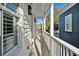 Narrow wooden porch with white pillars, wooden floor, and a view of the neighborhood at 402 Rose Wilder Ln, Mount Pleasant, SC 29464