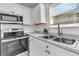 Galley kitchen featuring stainless appliances, white cabinets, and modern countertop overlooking the neighborhood at 415 Parkdale Dr # 12B, Charleston, SC 29414